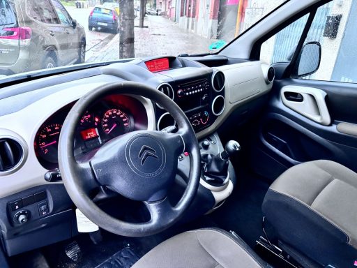 Interior de un vehículo, mostrando el volante, panel de control y asientos.